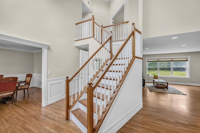 8 Tecumseh Ct, Commack, NY 11725 - staircase featuring wood finished floors, a towering ceiling, wainscoting, and recessed lighting