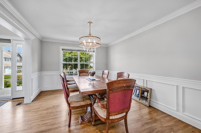 8 Tecumseh Ct, Commack, NY 11725 - dining space with a chandelier, ornamental molding, a wainscoted wall, light wood-type flooring, and a decorative wall