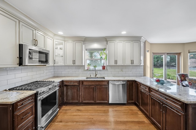 8 Tecumseh Ct, Commack, NY 11725 - kitchen with appliances with stainless steel finishes, a sink, a peninsula, light wood-type flooring, and dark brown cabinets