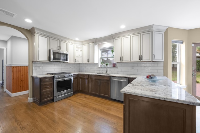 8 Tecumseh Ct, Commack, NY 11725 - kitchen with stainless steel appliances, a sink, a peninsula, healthy amount of natural light, and wainscoting