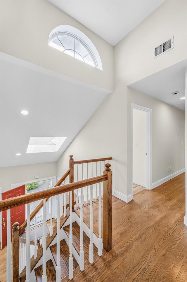 8 Tecumseh Ct, Commack, NY 11725 - corridor featuring a skylight, wood finished floors, plenty of natural light, baseboards, and recessed lighting