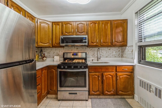17 Lawrence Dr Unit A, White Plains, NY 10603 - kitchen with stainless steel appliances, a sink, radiator heating unit, crown molding, and light countertops