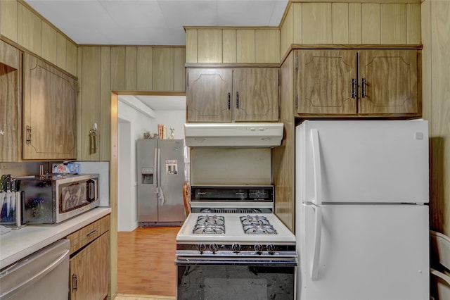62 Herman Blvd, Franklin Square, NY 11010 - kitchen featuring stainless steel appliances, under cabinet range hood, light countertops, and light wood finished floors
