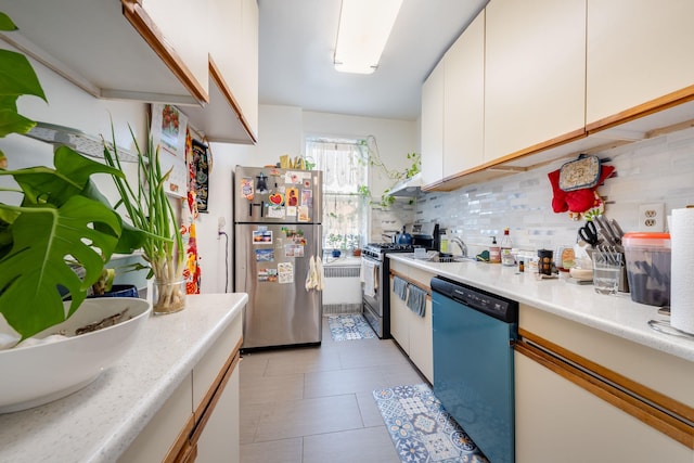 84-49 168th St Unit 6L, Jamaica Hills, NY 11432 - kitchen with appliances with stainless steel finishes, decorative backsplash, light countertops, white cabinetry, and light tile patterned flooring