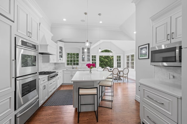 30 Salem Ridge Dr, Huntington, NY 11743 - kitchen with stainless steel appliances, a warming drawer, dark wood-style flooring, a kitchen bar, and vaulted ceiling