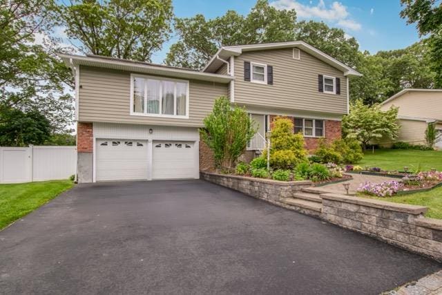 127 Parkview Rd, Elmsford, NY 10523 - tri-level home with a garage, driveway, and brick siding