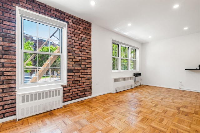 151-15 84th St Unit 1F, Howard Beach, NY 11414 - unfurnished living room with radiator, baseboards, brick wall, and recessed lighting
