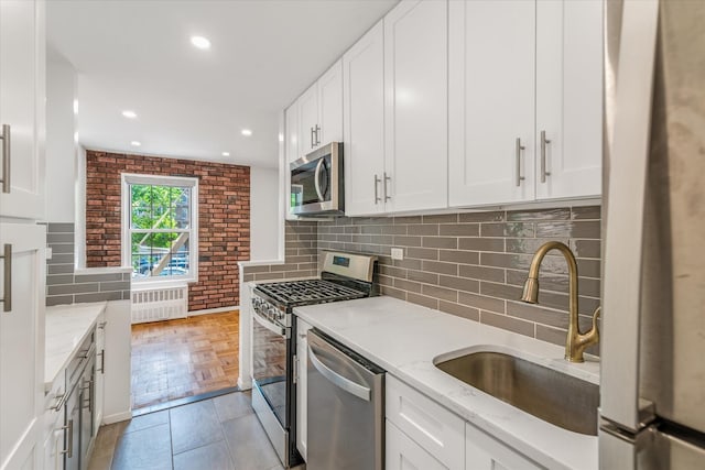 151-15 84th St Unit 1F, Howard Beach, NY 11414 - kitchen with radiator, appliances with stainless steel finishes, a sink, white cabinetry, and recessed lighting