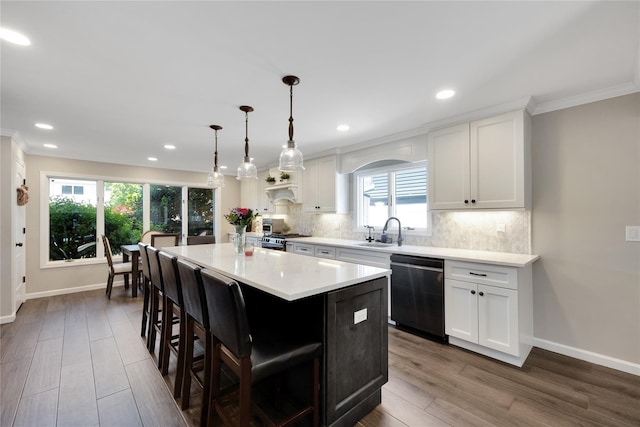 2985 Cheryl Rd, Merrick, NY 11566 - kitchen with dishwashing machine, a sink, crown molding, a center island, and baseboards