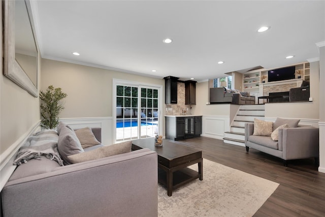 2985 Cheryl Rd, Merrick, NY 11566 - living room featuring a stone fireplace, wainscoting, ornamental molding, dark wood-style floors, and recessed lighting