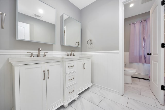 2985 Cheryl Rd, Merrick, NY 11566 - bathroom with toilet, wainscoting, double vanity, marble look tiles, and recessed lighting