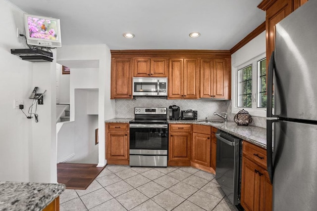 18 Birchwood Park Dr, Syosset, NY 11791 - kitchen with appliances with stainless steel finishes, tasteful backsplash, brown cabinetry, light tile patterned floors, and light stone countertops