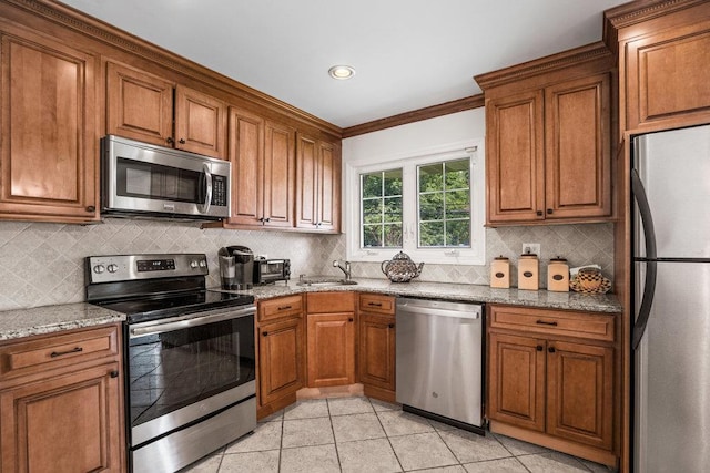18 Birchwood Park Dr, Syosset, NY 11791 - kitchen featuring appliances with stainless steel finishes, brown cabinetry, backsplash, a sink, and light stone counters