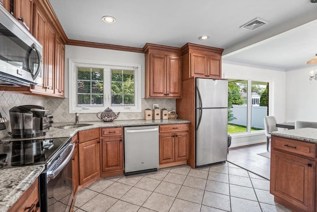 18 Birchwood Park Dr, Syosset, NY 11791 - kitchen with stainless steel appliances, a sink, brown cabinetry, plenty of natural light, and ornamental molding