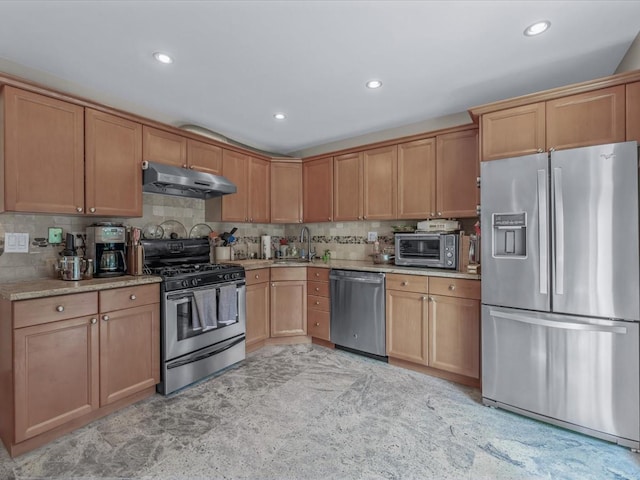 18 Ashland Ave, New Hyde Park, NY 11040 - kitchen with appliances with stainless steel finishes, under cabinet range hood, a sink, light countertops, and decorative backsplash