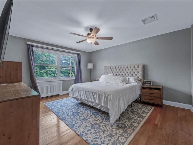 18 Ashland Ave, New Hyde Park, NY 11040 - bedroom featuring radiator, baseboards, wood finished floors, and a ceiling fan