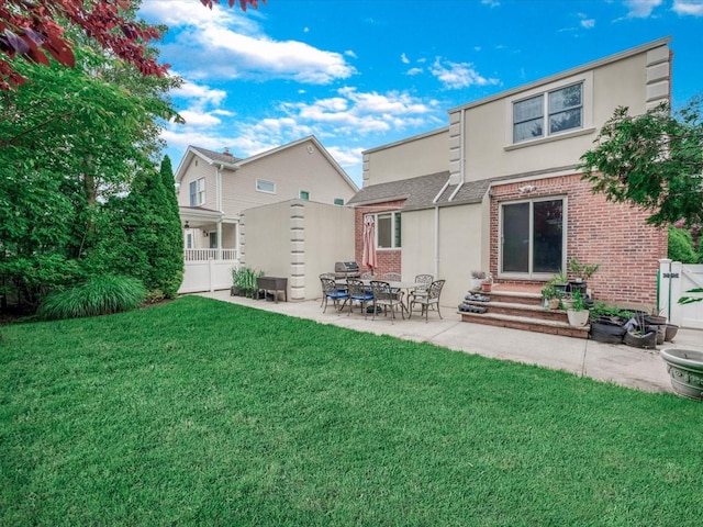 18 Ashland Ave, New Hyde Park, NY 11040 - rear view of house featuring stucco siding, a patio, and brick siding