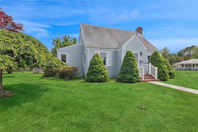 1295 Washington Ave, Greenport, NY 11944 - view of property exterior with a chimney, roof with shingles, and a lawn