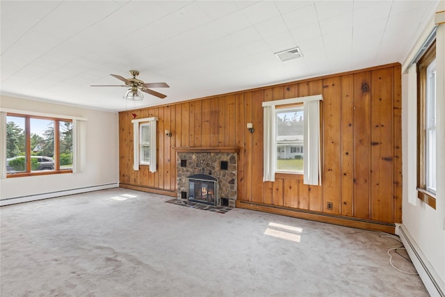 1295 Washington Ave, Greenport, NY 11944 - unfurnished living room featuring healthy amount of natural light, a baseboard heating unit, carpet flooring, and wood walls