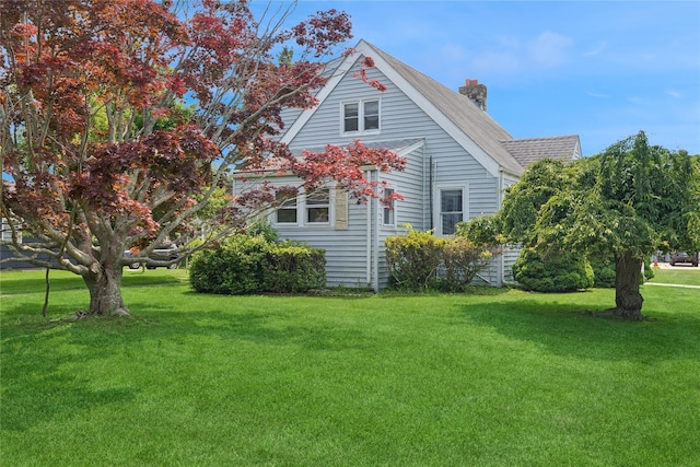1295 Washington Ave, Greenport, NY 11944 - view of side of home featuring a chimney, a lawn, and roof with shingles