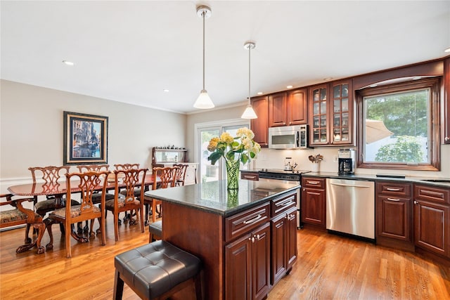 4 Valley Rd, Syosset, NY 11791 - kitchen featuring stainless steel appliances, light wood-type flooring, glass insert cabinets, decorative light fixtures, and a kitchen island