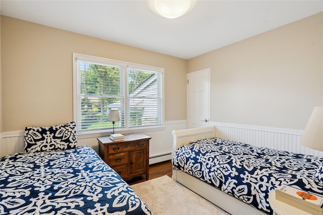 4 Valley Rd, Syosset, NY 11791 - bedroom with a wainscoted wall, a baseboard heating unit, and wood finished floors