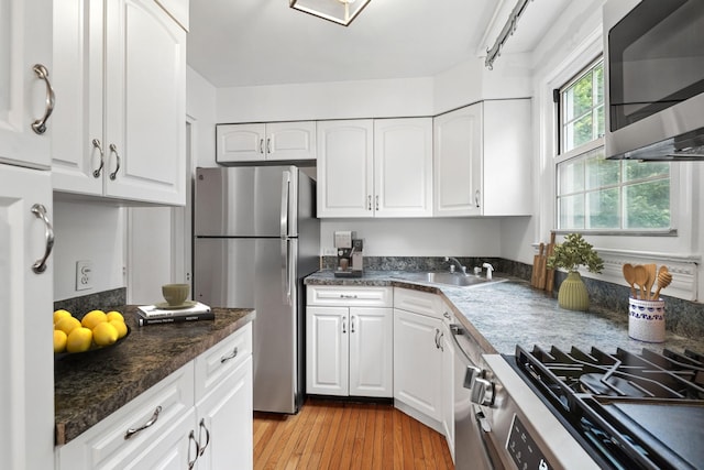 11 Sentry Pl Unit 2C, Scarsdale, NY 10583 - kitchen featuring stainless steel appliances, white cabinetry, light wood-style flooring, and dark countertops