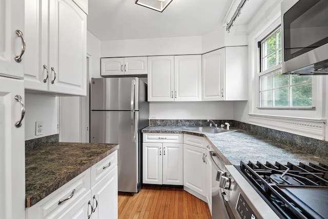11 Sentry Pl Unit 2C, Scarsdale, NY 10583 - kitchen featuring appliances with stainless steel finishes, white cabinets, and dark countertops