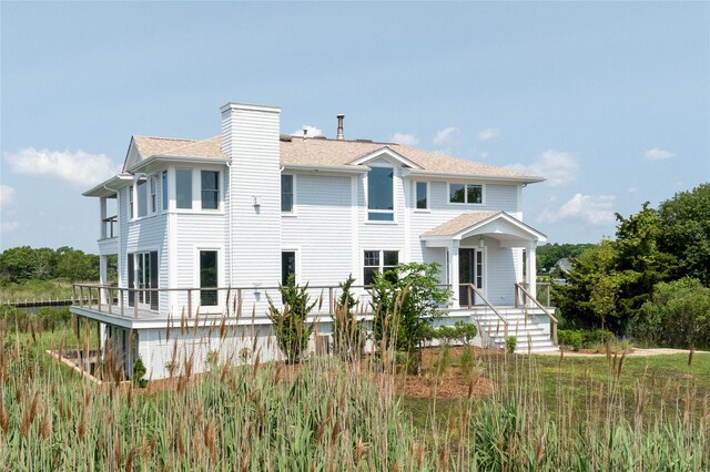 7 Convent Ln, Center Moriches, NY 11934 - view of front of property featuring a shingled roof and a chimney