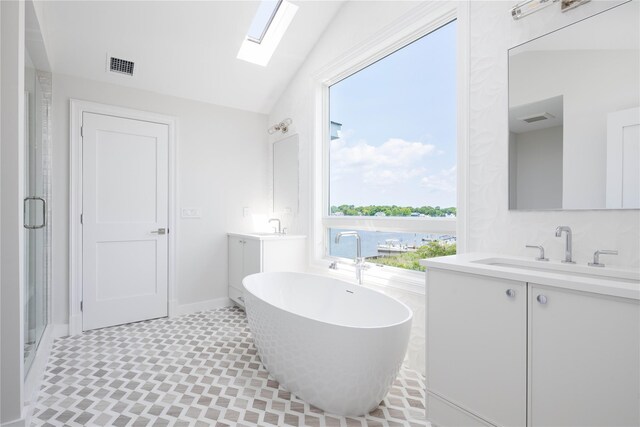 7 Convent Ln, Center Moriches, NY 11934 - full bath with a skylight, vaulted ceiling, two vanities, a freestanding bath, and a stall shower