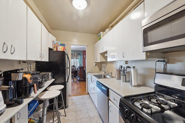 3 Fordham Hill Oval Unit 10B, Bronx, NY 10468 - kitchen with stainless steel appliances, a sink, white cabinets, light countertops, and light tile patterned floors