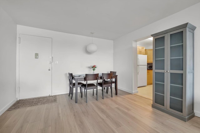 2 Bay Club Dr Unit 2B, Bayside, NY 11360 - dining area featuring light wood-type flooring and baseboards