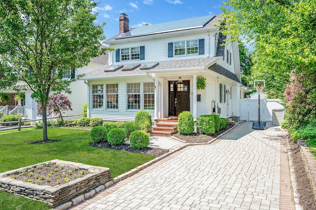 85 Fairmount St, Huntington, NY 11743 - view of front facade with solar panels, a gate, and a chimney
