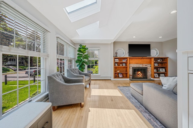 85 Fairmount St, Huntington, NY 11743 - living room with light wood-type flooring, a glass covered fireplace, a skylight, baseboard heating, and recessed lighting