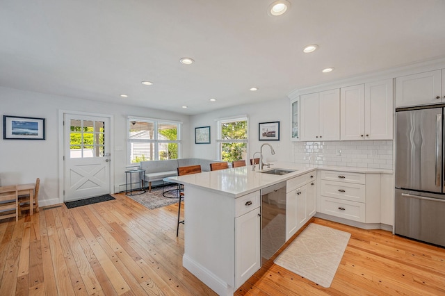 85 Fairmount St, Huntington, NY 11743 - kitchen with stainless steel appliances, a sink, light wood finished floors, a peninsula, and recessed lighting