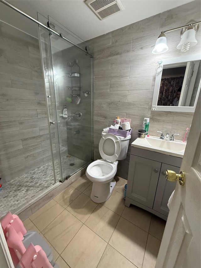 57-54 Xenia St, Corona, NY 11368 - bathroom with tile patterned floors, vanity, a shower stall, toilet, and tile walls