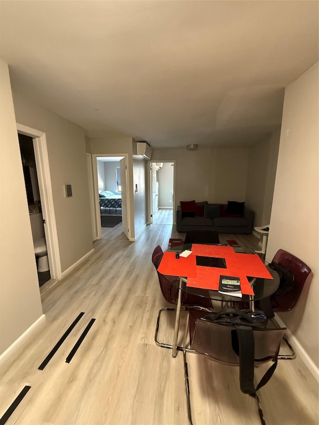 57-54 Xenia St, Corona, NY 11368 - dining area with an AC wall unit, light wood-style flooring, and baseboards