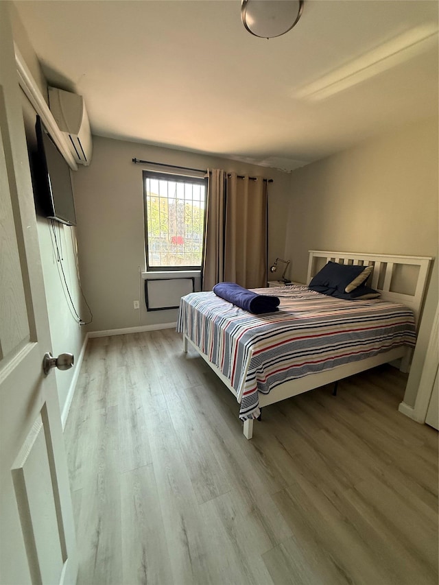 57-54 Xenia St, Corona, NY 11368 - bedroom with wood finished floors, a wall mounted air conditioner, and baseboards