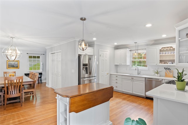 319 Thompson St, Port Jefferson, NY 11777 - kitchen with appliances with stainless steel finishes, a sink, healthy amount of natural light, crown molding, and white cabinetry