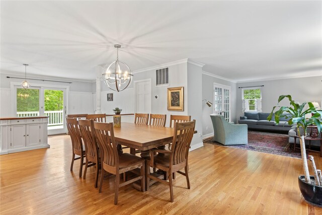 319 Thompson St, Port Jefferson, NY 11777 - dining room with a chandelier, light wood-style flooring, and crown molding