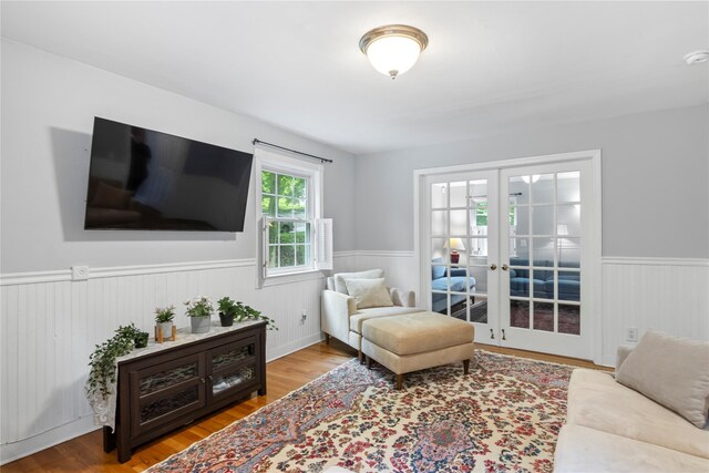 319 Thompson St, Port Jefferson, NY 11777 - living area featuring a wainscoted wall, french doors, and wood finished floors