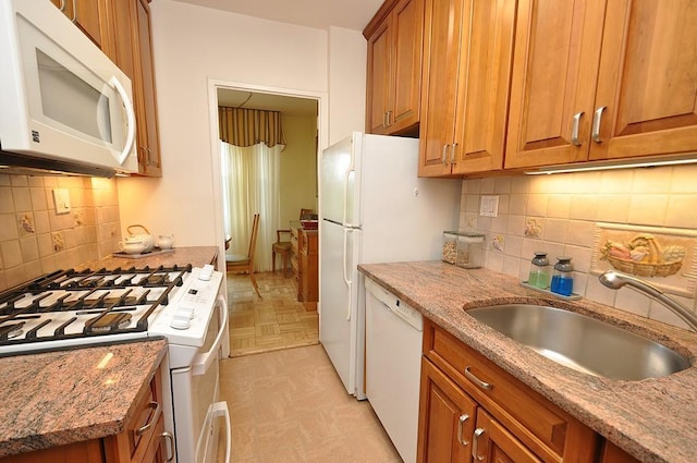 230 Garth Rd Unit 6C1, Scarsdale, NY 10583 - kitchen featuring white appliances, a sink, brown cabinets, and light stone countertops