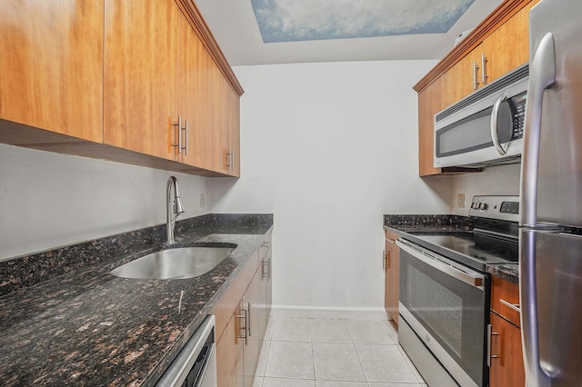 136 Bch 117th St Unit 6H, Rockaway Park, NY 11694 - kitchen with stainless steel appliances, a sink, light tile patterned flooring, baseboards, and dark stone countertops