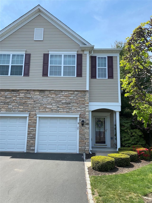 28 Torrey Pine Ln, Bay Shore, NY 11706 - townhome / multi-family property featuring stone siding, driveway, and a garage