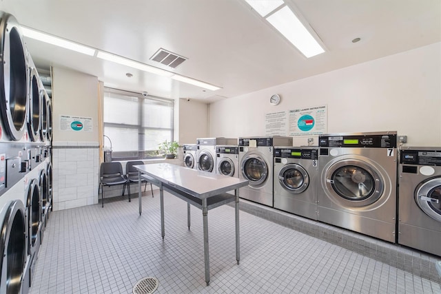 23 Water Grant St Unit 7N, Yonkers, NY 10701 - shared laundry room featuring stacked washing machine and dryer, tile patterned flooring, washer and clothes dryer, and wainscoting