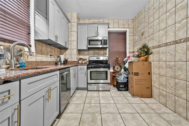 114-11 86th Ave, Richmond Hill North, NY 11418 - kitchen with appliances with stainless steel finishes, a sink, gray cabinets, light tile patterned flooring, and stone counters
