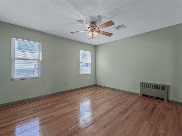 82-44 263rd St, Glen Oaks, NY 11004 - unfurnished room featuring radiator, wood finished floors, and a ceiling fan