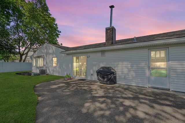 1340 Stony Brook Rd, Stony Brook, NY 11790 - back of house at dusk featuring a chimney and a patio