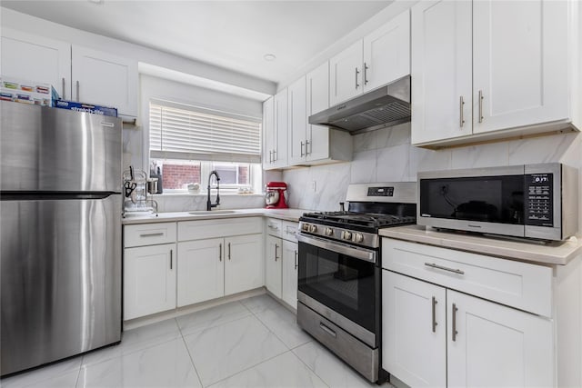 628 151st St, Whitestone, NY 11357 - kitchen with stainless steel appliances, under cabinet range hood, a sink, white cabinetry, and light countertops