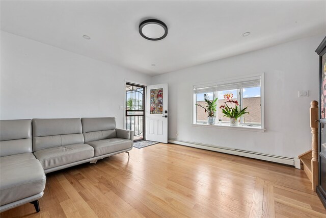 628 151st St, Whitestone, NY 11357 - living room with a baseboard heating unit and light wood-style flooring